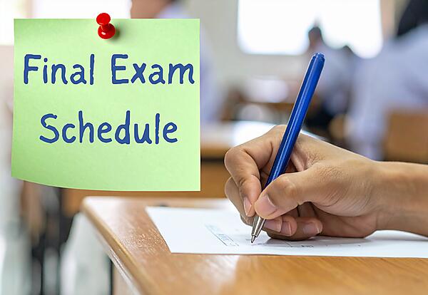 Final Exam Schedule on photo of a hand taking a test