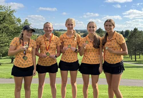 five girls in golf uniforms holding medals