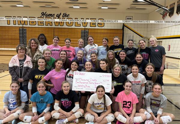 volleyball team surrounds oversized check