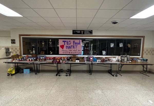 a table in a school hallway filled with food items
