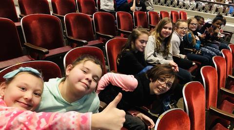 Students  giving thumbs up in theater chairs