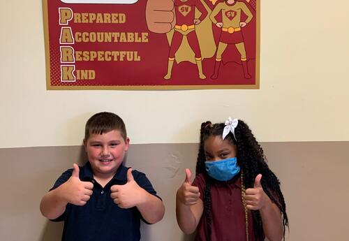 Two students giving a thumbs up