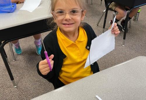 Student with scissors and paper