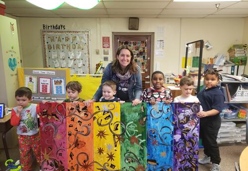 Teacher with students their artwork