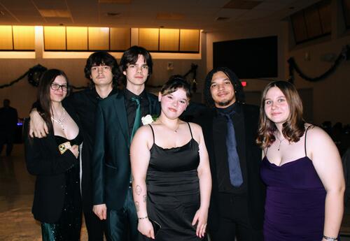 Six students in their winter formal attire pose for a photo
