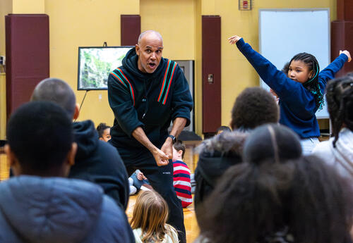 A performer with the cultural trust interacts with students