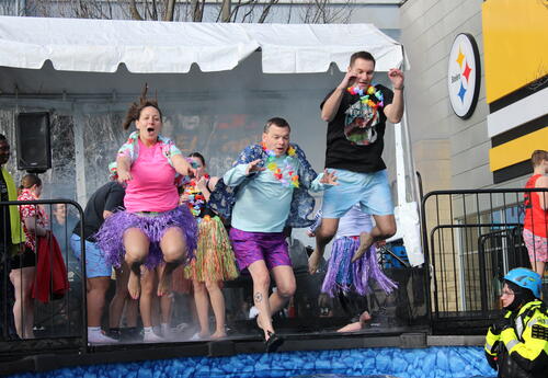 Three SV staff members jumping into a pool