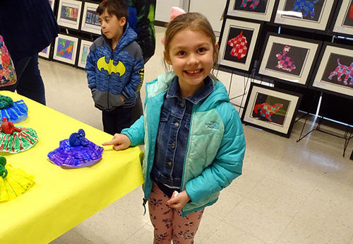 student displaying artwork