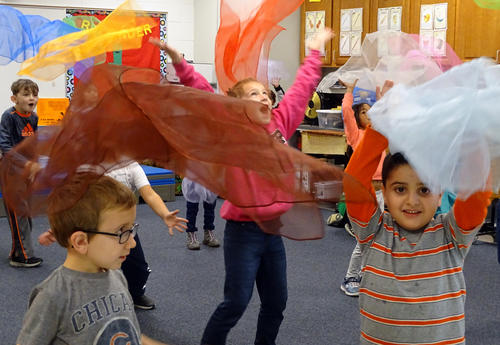 students joyfully playing with scarves