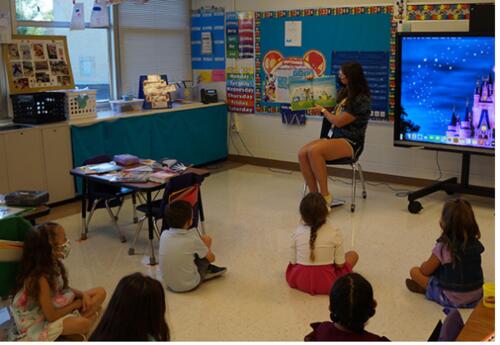 Andrew Athlete reading to elementary students