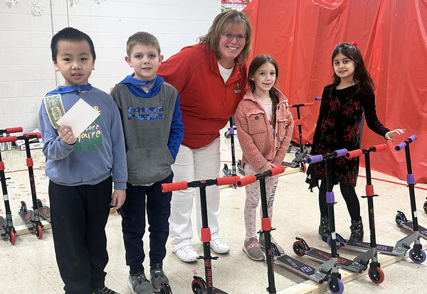 Smiling students with Fernway Principal with scooters