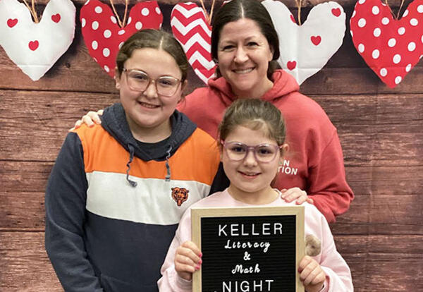 Family of three pose for photo at Keller Literacy and Math Night