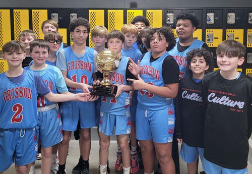 Grissom 6th/7th Grade Boys' Basketball team proudly pose with basketball trophy