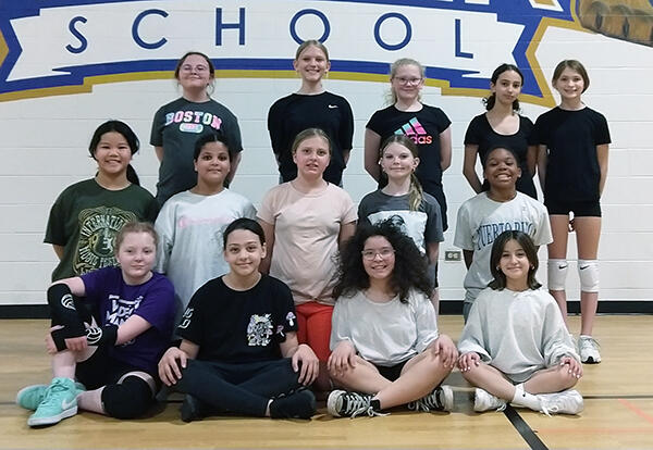 Keller girls' volleyball team pose proudly in school gym