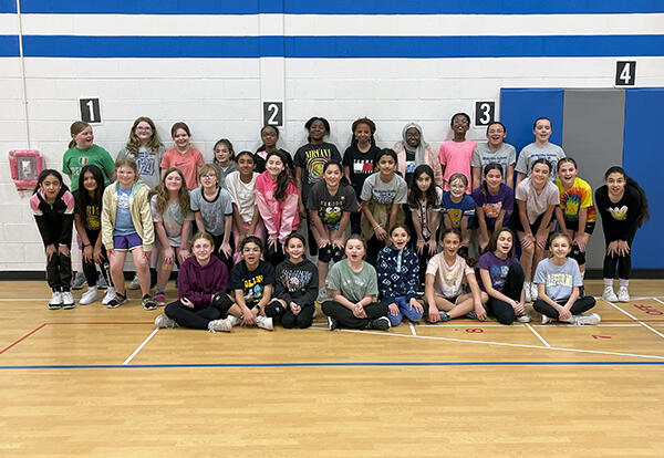 McAuliffe girls' volleyball pose proudly in school gym