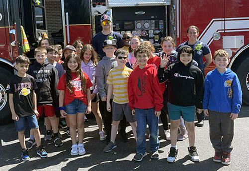Third grade class pose with Tinley Park fire fighters in front of fire truck