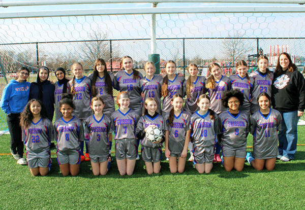 Grissom girls' soccer team pose proudly with coach at end of season