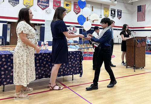 Student receiving certificate at NJHS ceremony