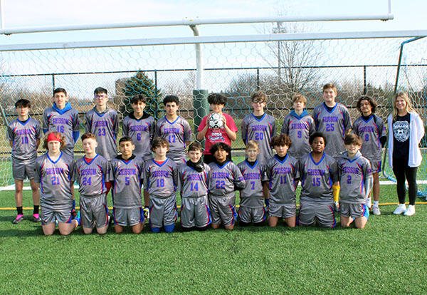 Grissom boys' soccer team pose proudly with coach at end of season