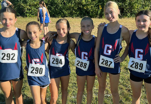 Group of girls' Cross Country team pose before race at Troy Invitational