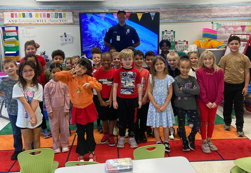 Fernway first grade student pose proudly with Orland Park Fire Department Firefighter