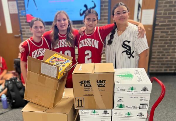 Students pose proudly with boxes of candy collected for Treats for Troops