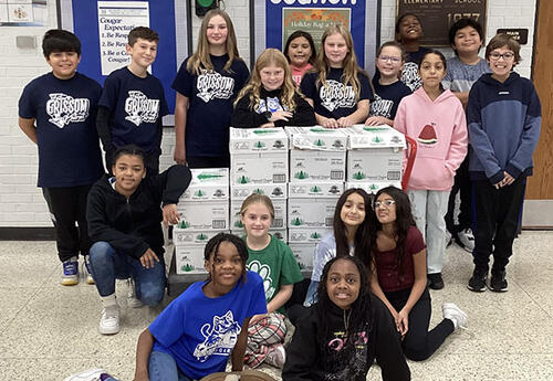 Student Council members pose proudly with food collected from Food Drive