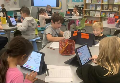 Group of students work on ipads in media center