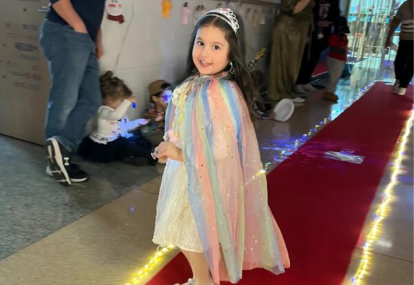 Preschool student poses on the runway for Fashion Show event