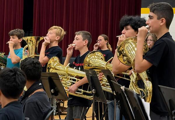 Band members playing instruments during showcase for fifth graders