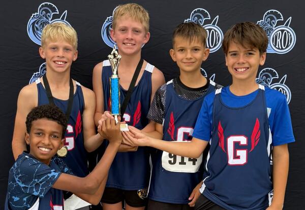 Sixth grade boys cross country members pose with fourth place trophy at Troy Invitational