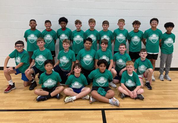 Millennium boys' basketball team pose proudly in school gym after practice