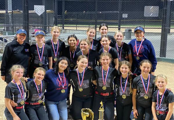 Grissom girls' softball team pose proudly with trophies and medals