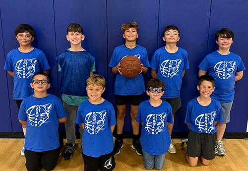Keller boys' basketball team pose proudly in school gym with a basketball