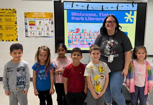 Six students pose proudly with Tinley Park Librarian after presentation