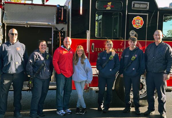 Grissom Fire Prevention poster winner poses with Tinley Park fire fighters and Superintendent after getting a ride to school in fire truck