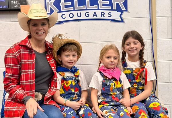 Principal and students pose proudly in farm-themed attire during family reading night