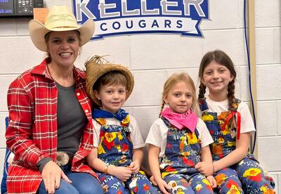 Principal and students pose proudly in farm-themed attire during family reading night