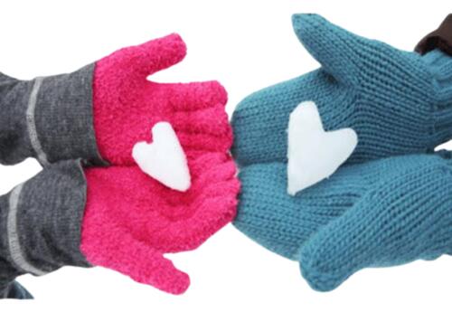 Two sets of hands with different colored gloves holding heart shaped piece of snow