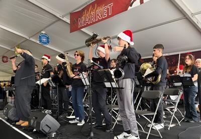 Jazz Ensemble smiles on stage at Tinley Park Holiday Market after performance