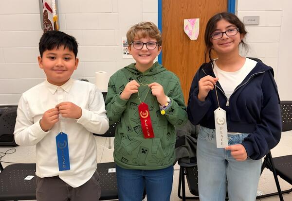 McAuliffe top three Spelling Bee winners pose proudly with ribbons