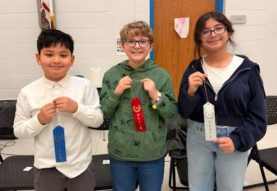 McAuliffe top three Spelling Bee winners pose proudly with ribbons