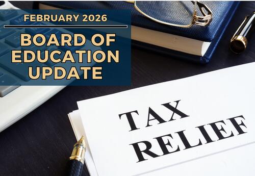 A calculator, a notebook with glasses and a pen, and a document titled TAX RELIEF are arranged on a dark surface.