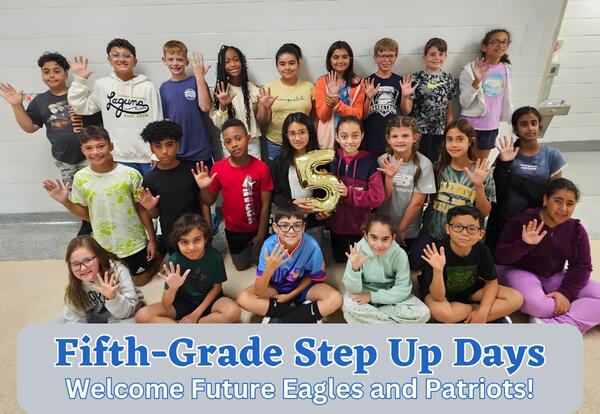 Group of fifth-grade students pose for picture in school hallway