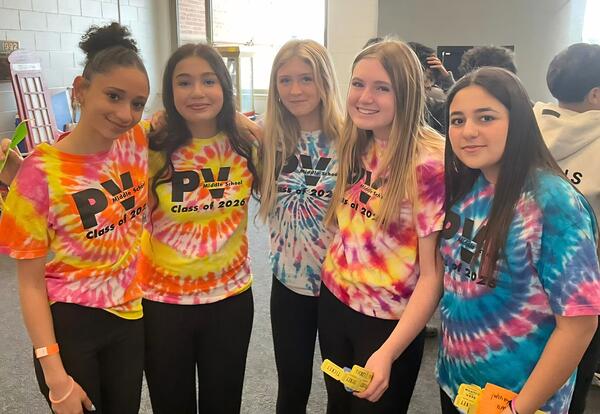 Five students pose for a photo wearing tie-dye shirts that say "PV Class of 2026".