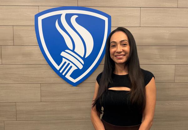 Director of Business Services poses with Kirby School Logo.