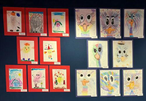 A wall display featuring students' artwork, including birds and figures