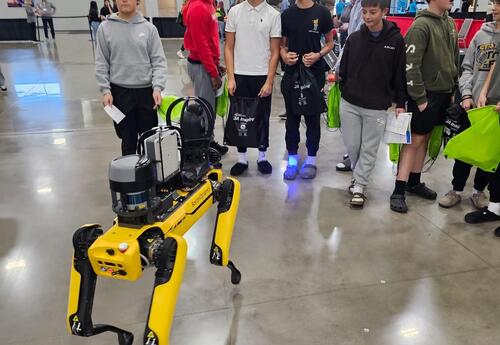 Students standing around robot