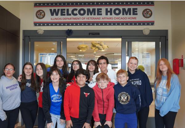 students posing in the lobby entrance of the veterans home