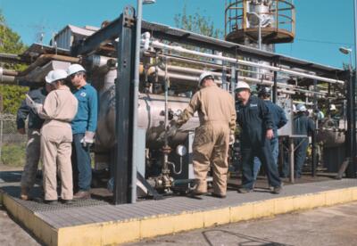 Men work at the methanol plant on the Nunez campus.